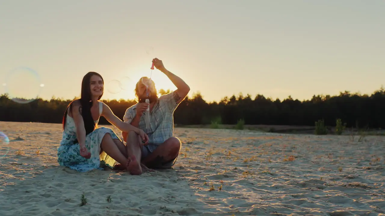 Young Family Having Fun With Kids Blow Bubbles At Sunset