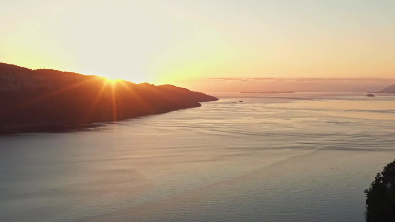 Beautiful Vibrant Sun Peaking behind mountain in Vancouver Canada during Golden Hour