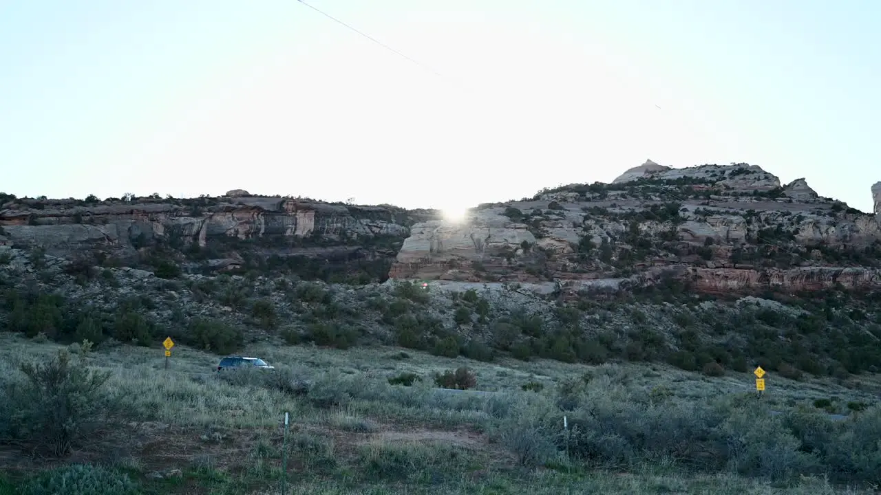 Sun setting behind red rock mountains in the Colorado National Monument time lapse