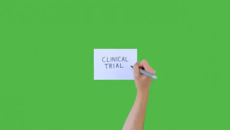 Woman Writing Clinical Trials on Paper with Green Screen