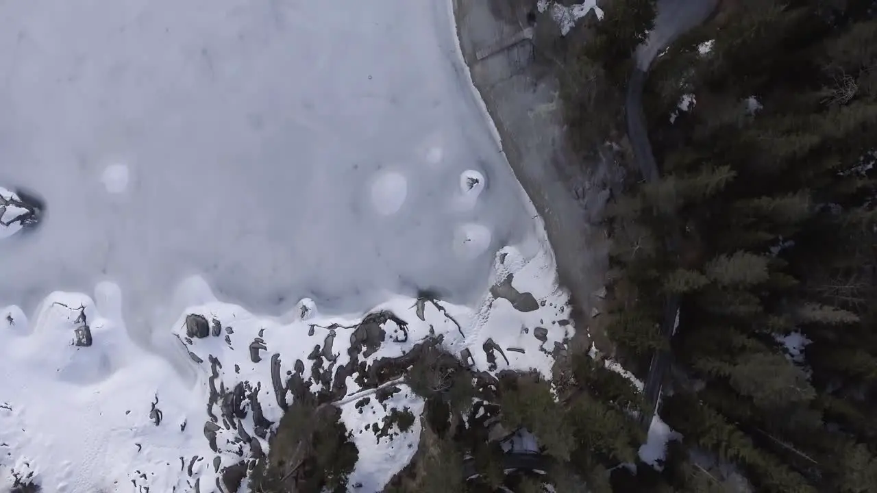 Flight over a road surrounded by trees and a lake