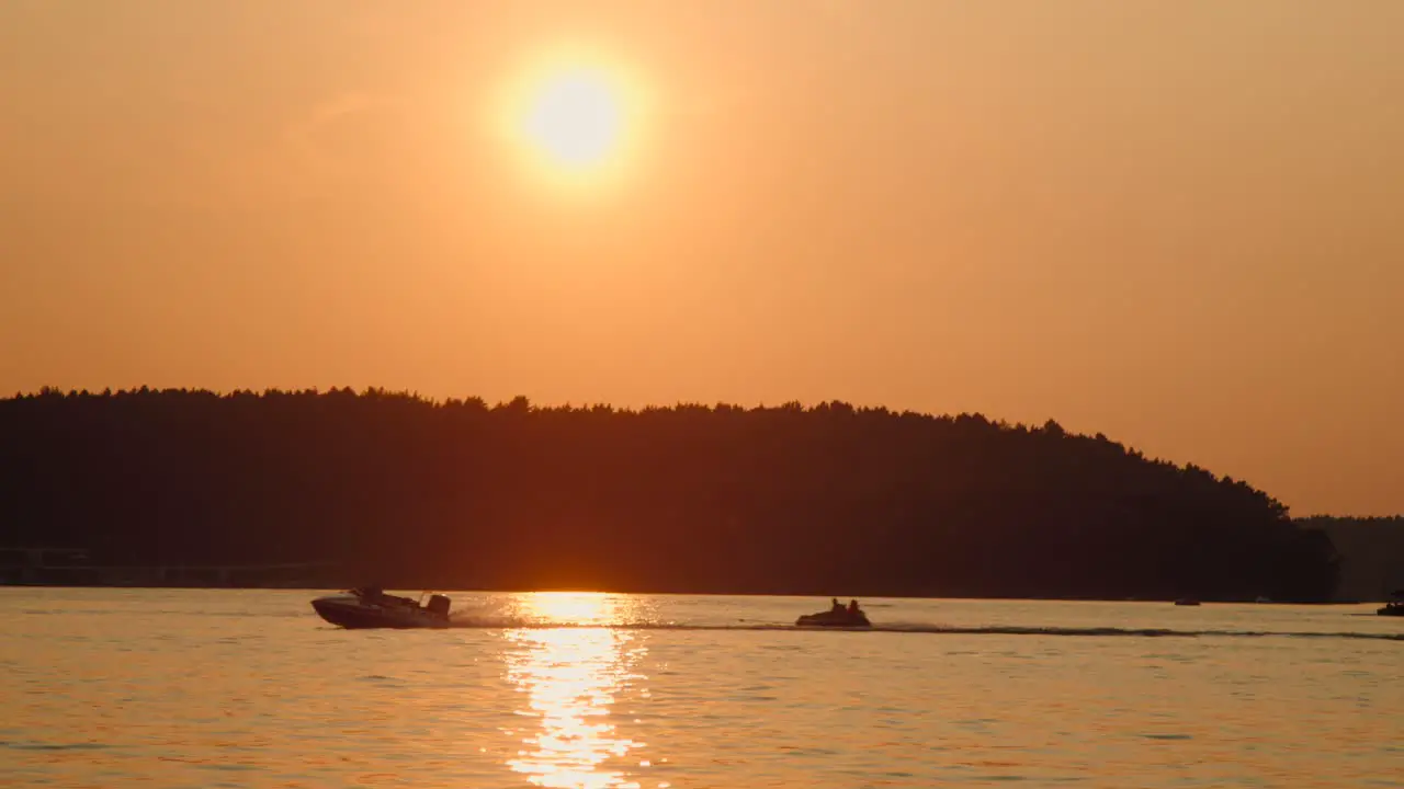 Motor boat speeds down the lake at sunset