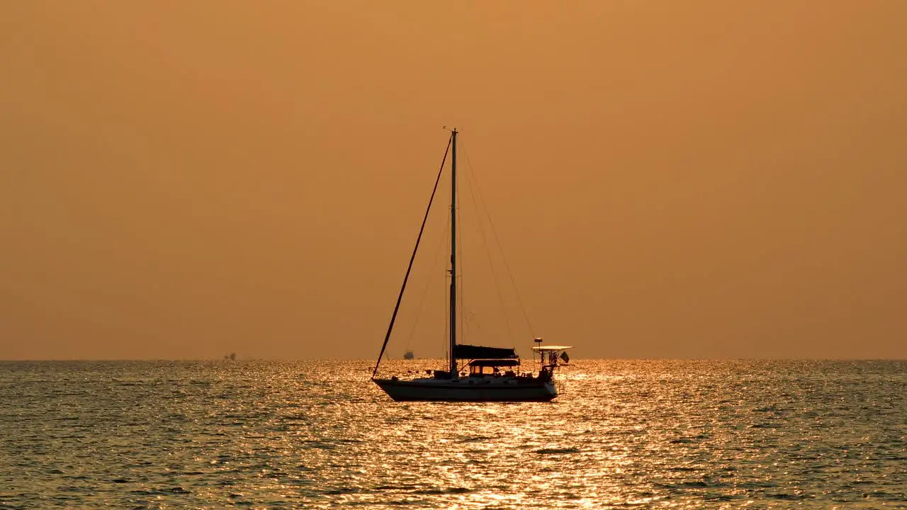 Yacht on the Horizon with Orange Glow Sunset in Bangsaray near Pattaya Thailand