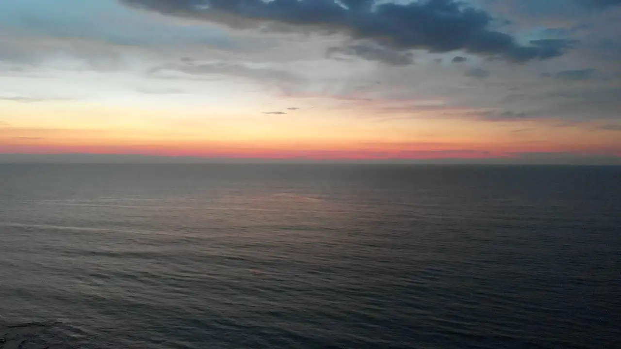 Descending aerial of sunset over sea in La Union Philippines