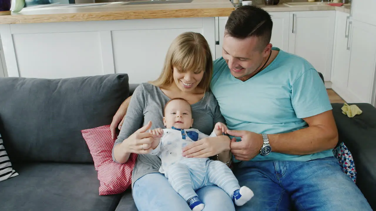 A Young Family With A Baby At Home Naughty Baby Dad Stroking His Belly The Child Tummy Ache