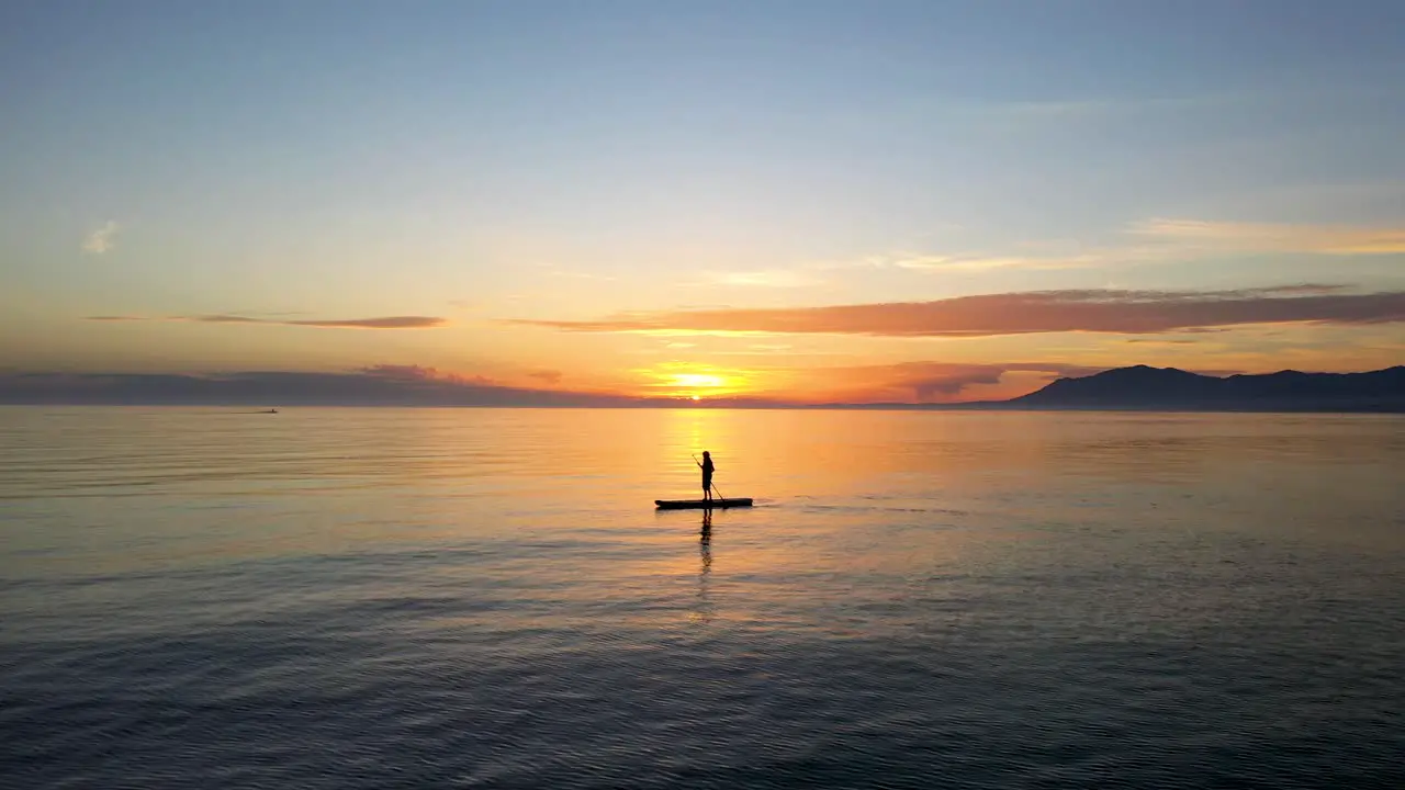 beautiful view of a silhouette paddle surfing at sunset in on the Mediterranean sea just off the coast of Marbella dream holiday