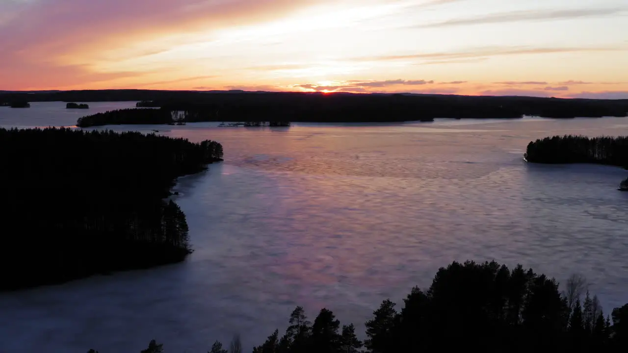 Drone shot of frozen lake with islands by the golden hour