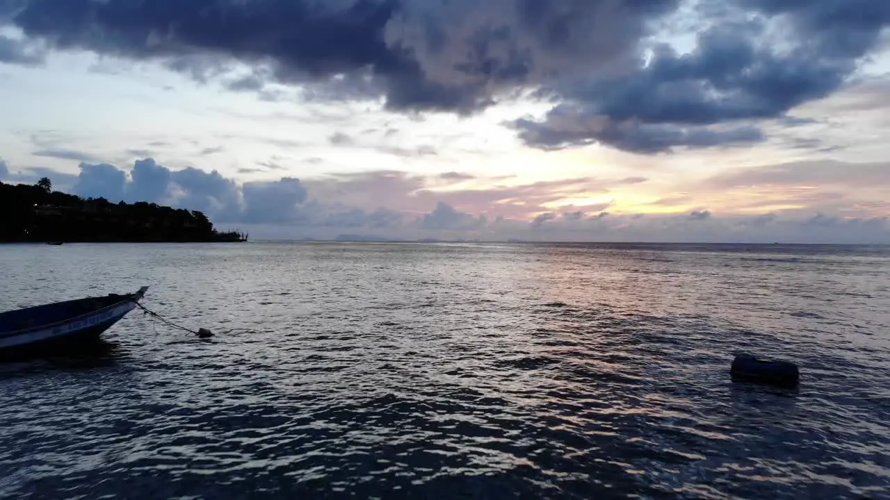 Small Local Fishing Boats in Southeast Asia swaying on the Sea during Beautiful Sunset Drone Shot