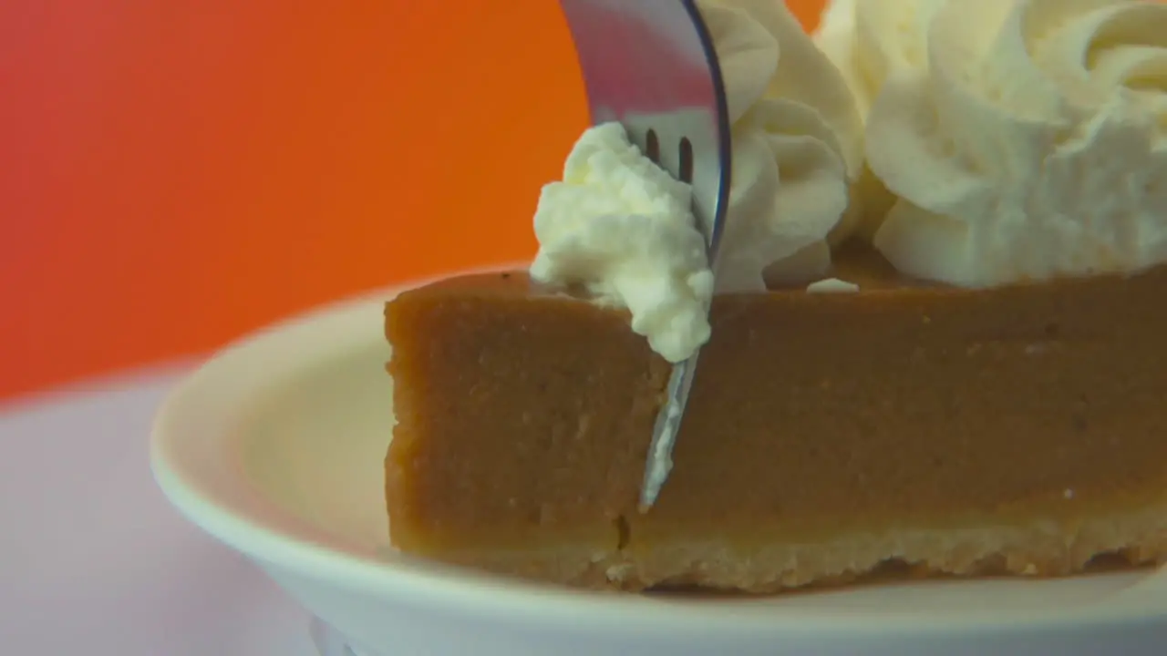 [Camera Used Canon C300] Macro shot of a fork taking a bite out of a pumpkin pie slice