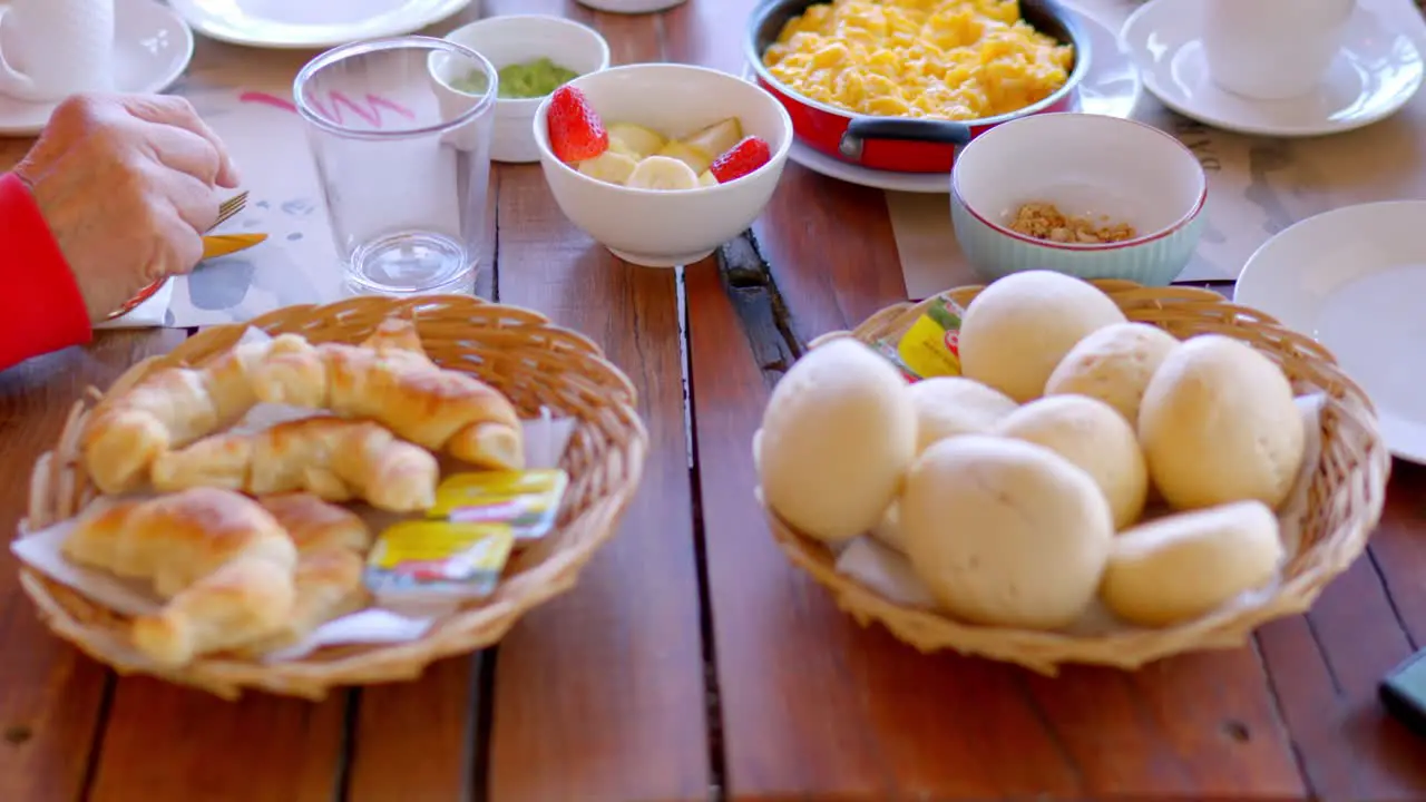 Hotel table with breakfast served homemade kneaded bread and freshly baked croissant are seen