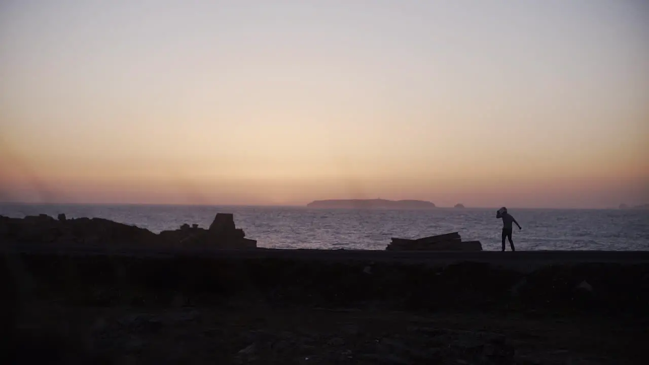 Golden sunset and silhouette of skater on the beach