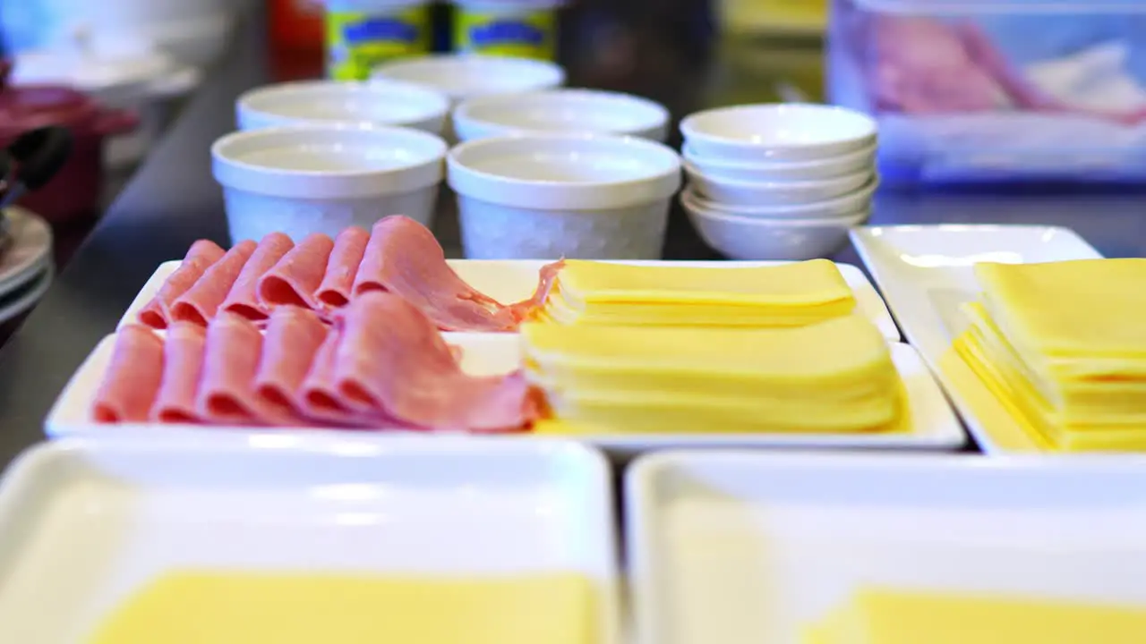 person preparing a breakfast serving ham and cheese