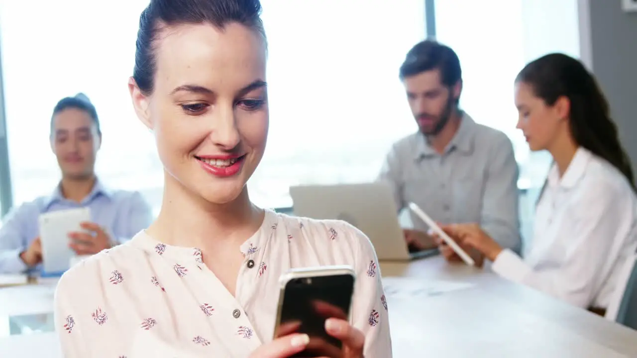 Female business executive using mobile phone