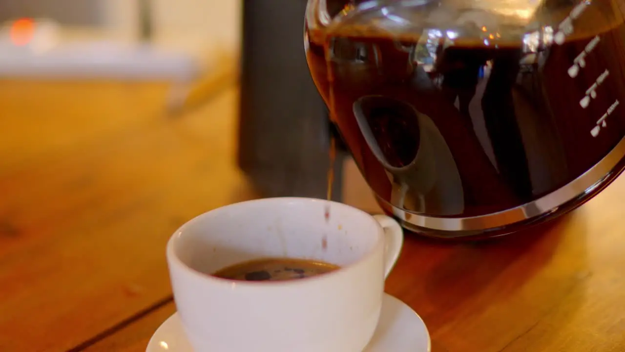 gourmet coffee beans prepared in a coffee pot being served in a white cup