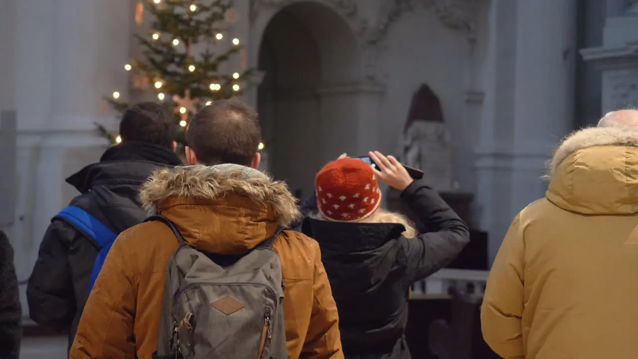 Blonde Women taking a photograph with her mobile phone inside the Theatiner Church in Munich