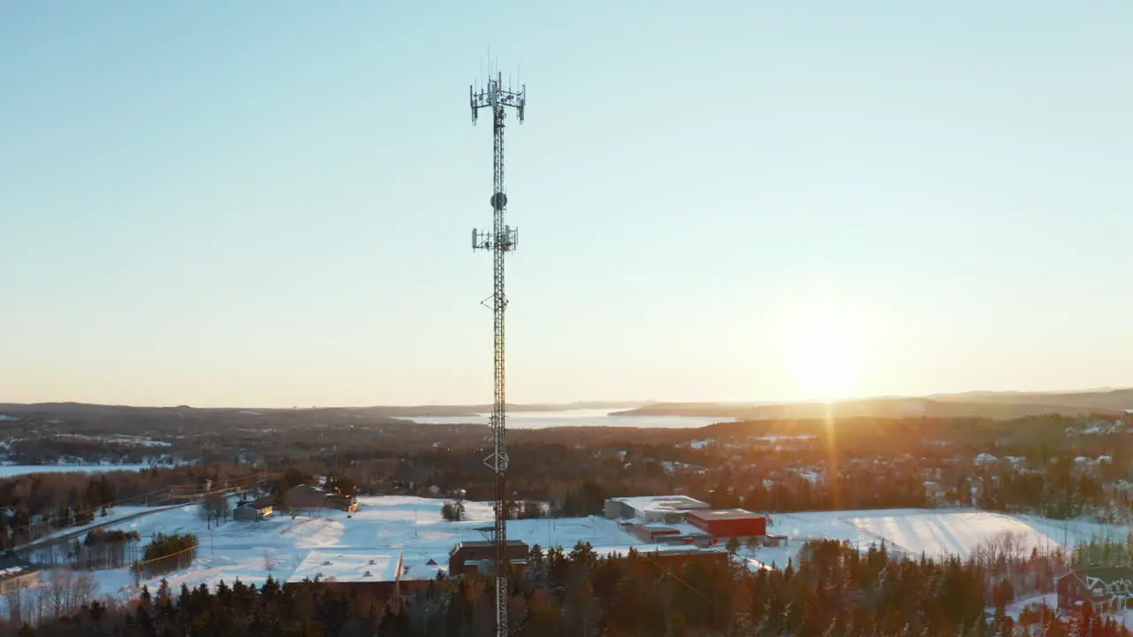 Aerial view of a cell phone tower in a snowy suburban neighborhood at sunset