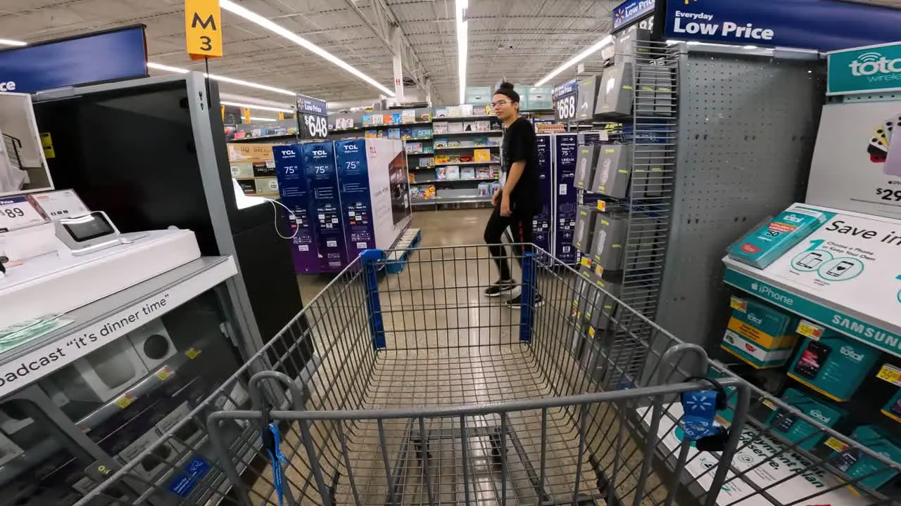 POV while pushing a cart through Walmart in electronics section