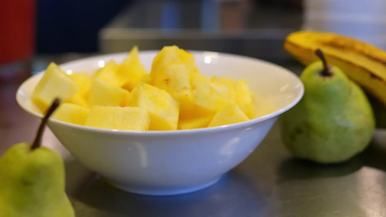 bowl full of fresh and tasty pineapple next to pears