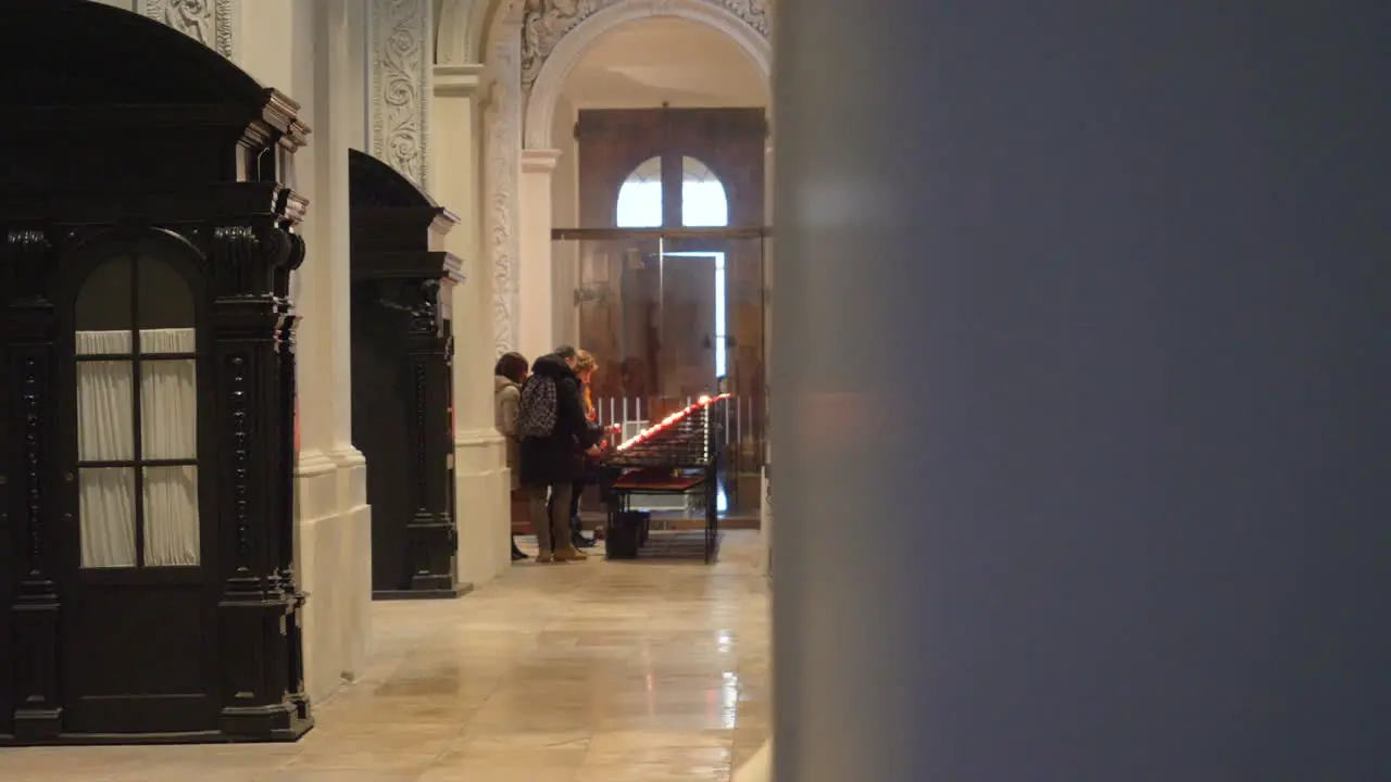 Group of tourists lighting a candle inside the Theatiner Church in Munich