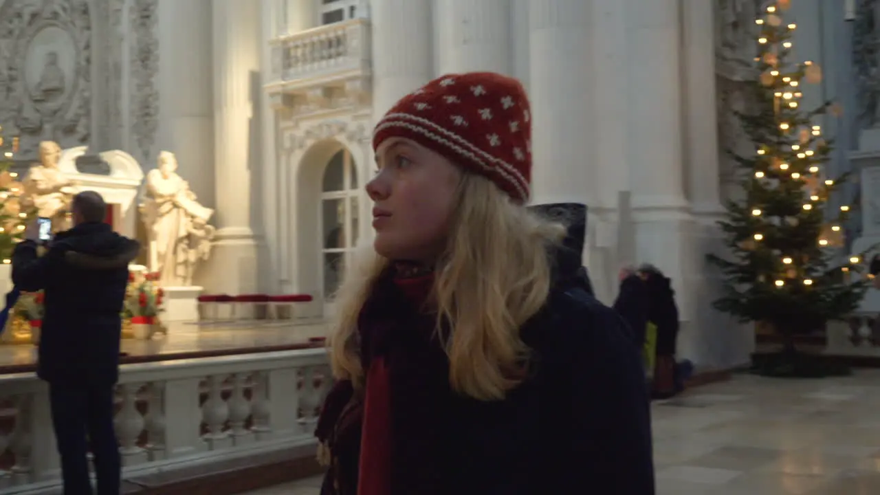 Blonde woman looking around the inside of the Theatiner Church in Munich