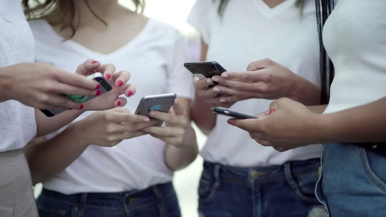 Closeup shot of female hands typing on smartphones