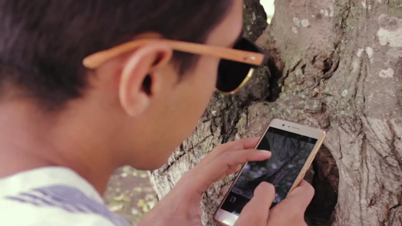 young man using his cell phone to take photos of nature