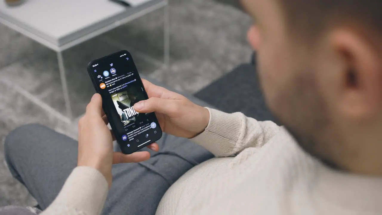 Close view of man scrolling through social network apps on smartphone