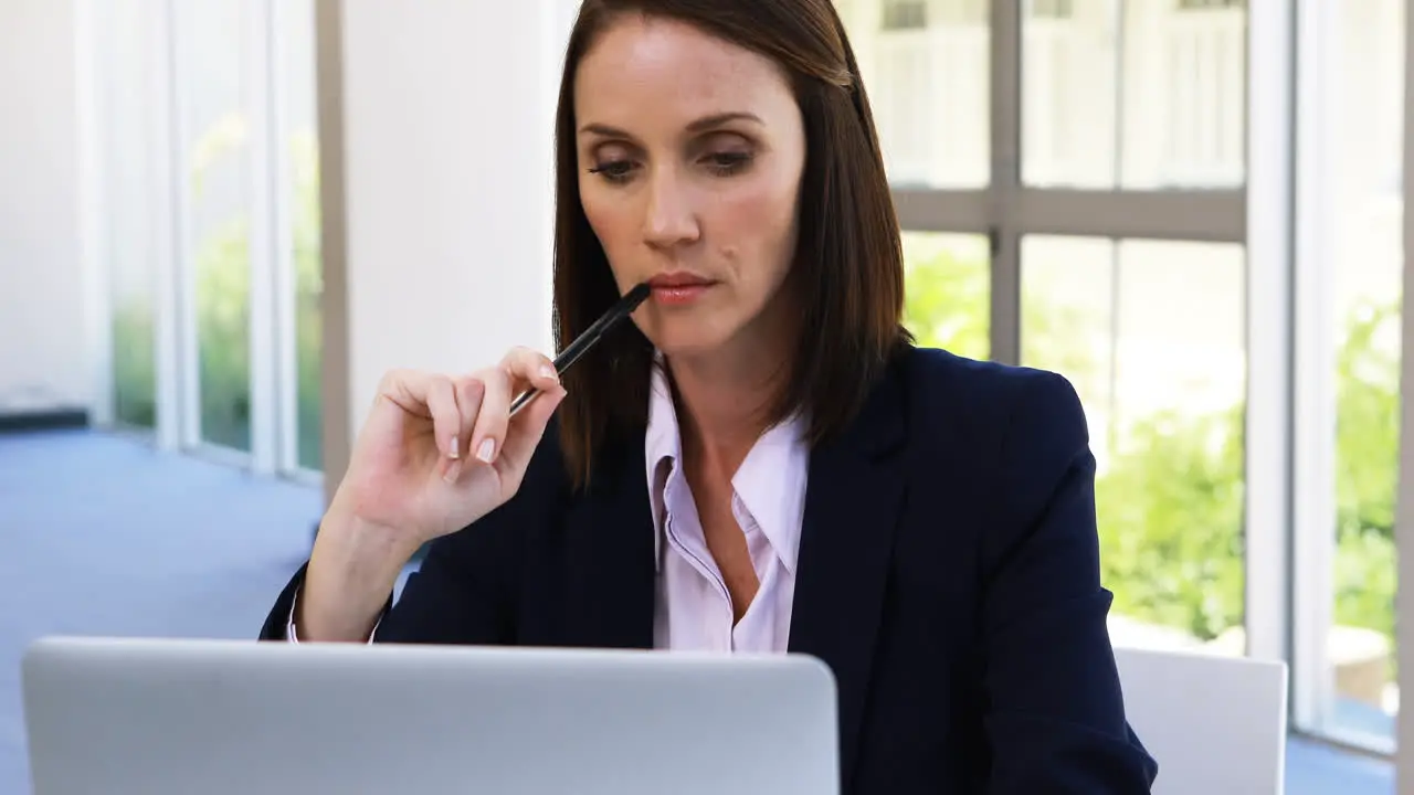 Businesswoman working on laptop at desk 4k