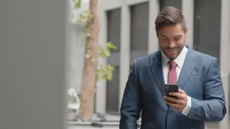 Businessman Outside City Of London Offices Using Mobile Phone