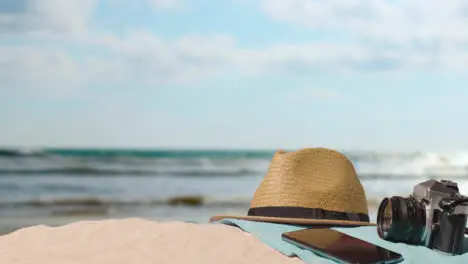 Summer Holiday Concept Of Camera Sun Hat Mobile Phone Beach Towel On Sand Against Sea 1