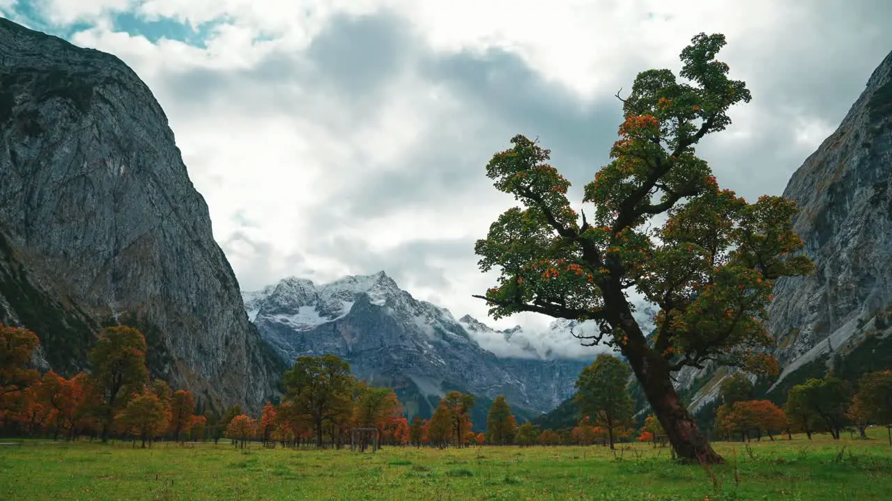 4K UHD time lapse cinemagraph of moving clouds in Austrias famous alps mountains area Ahornboden Hinterriss close to the German border in Autumn weather with colorful maple trees