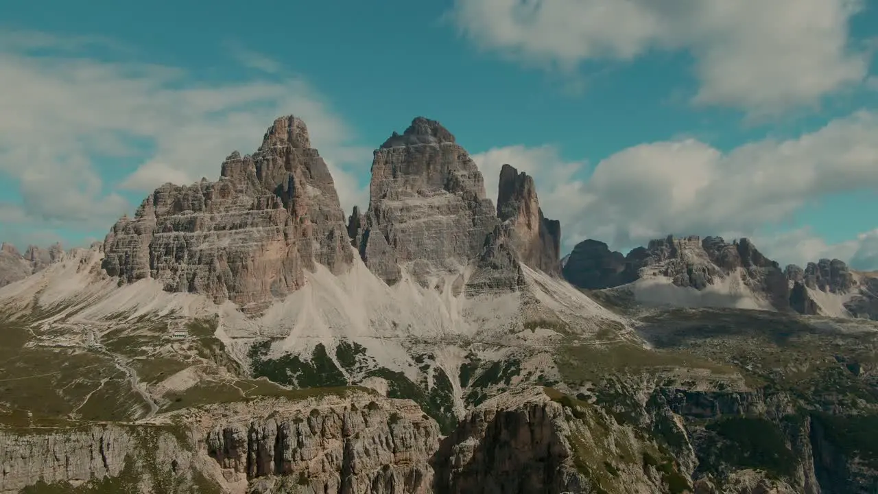 Tracking drone shot with tall steep rocky mountains and partly clouded sky in the background Vacation and Holiday in the Alps majestic landscape cinematic color grade