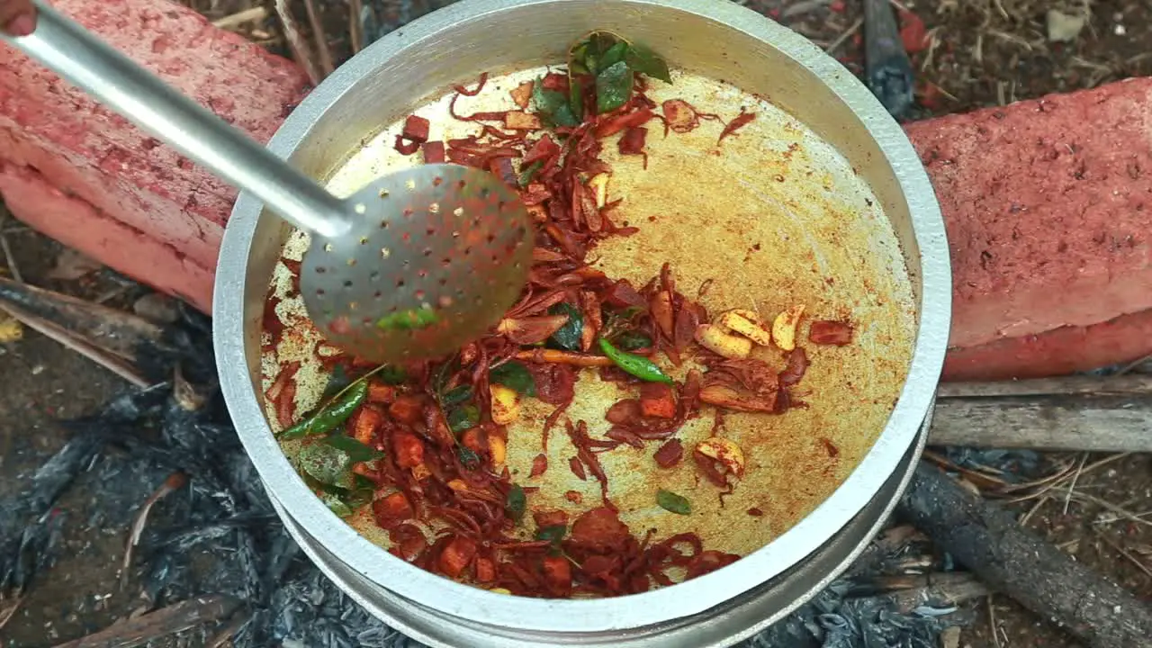 Add masala mix and neem leaves and stir  black clam masala curry traditional outdoor black clams cooking pollution  masala  brick