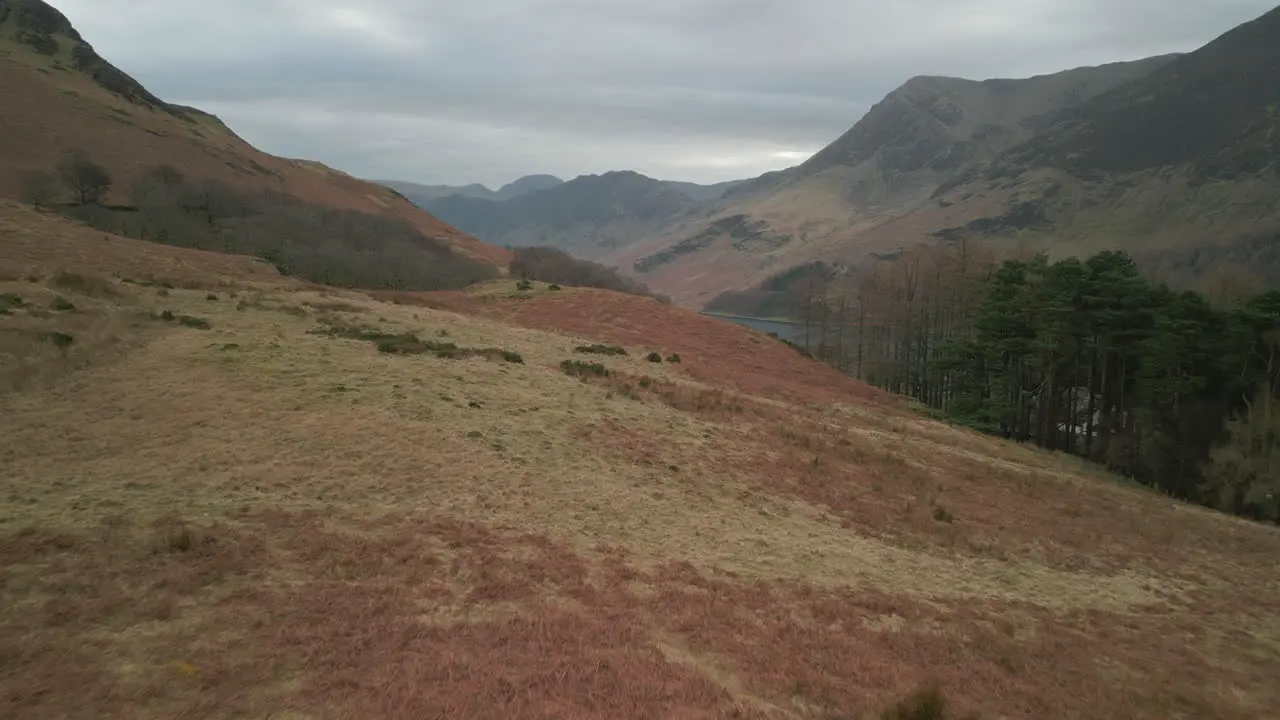 Flying over hiker walking across moorland towards distant mountains at Buttermere English Lake District UK