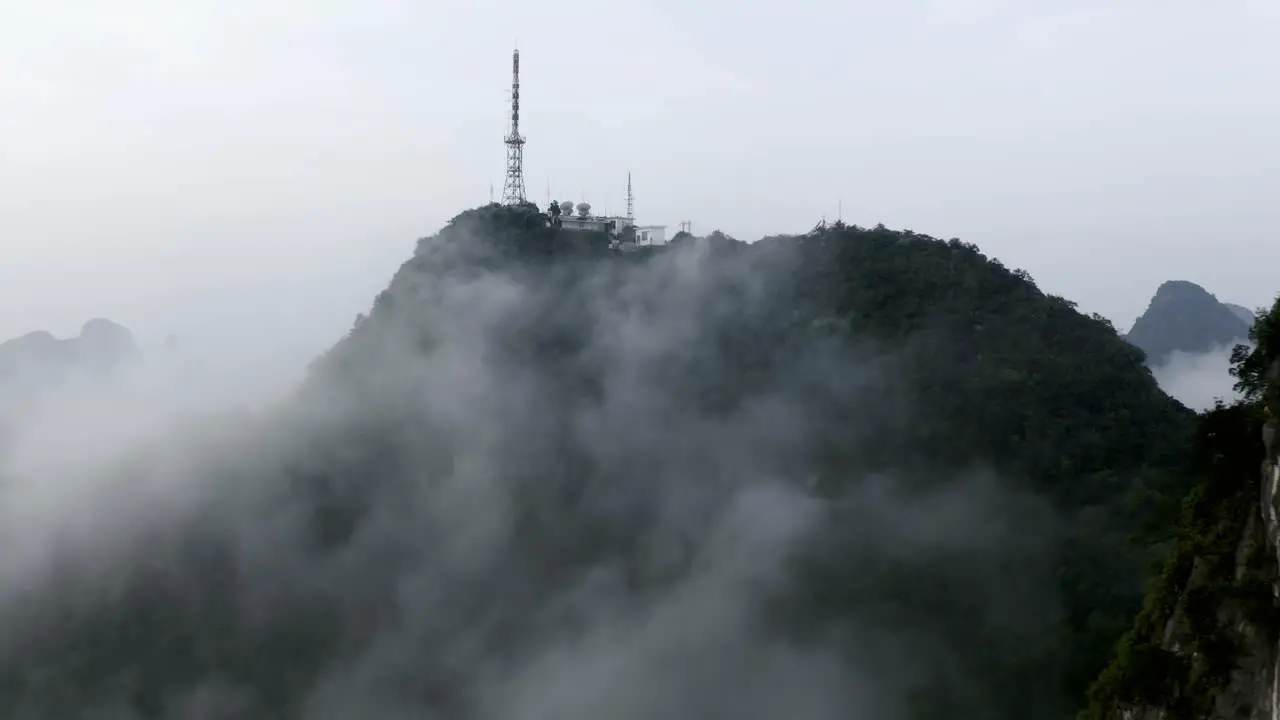 Yangshuo mountains 4k drone pull back from Tv Tower above the misty clouds