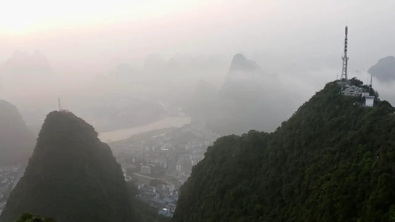 4k drone through mountains around Tv Tower above the misty clouds guilin