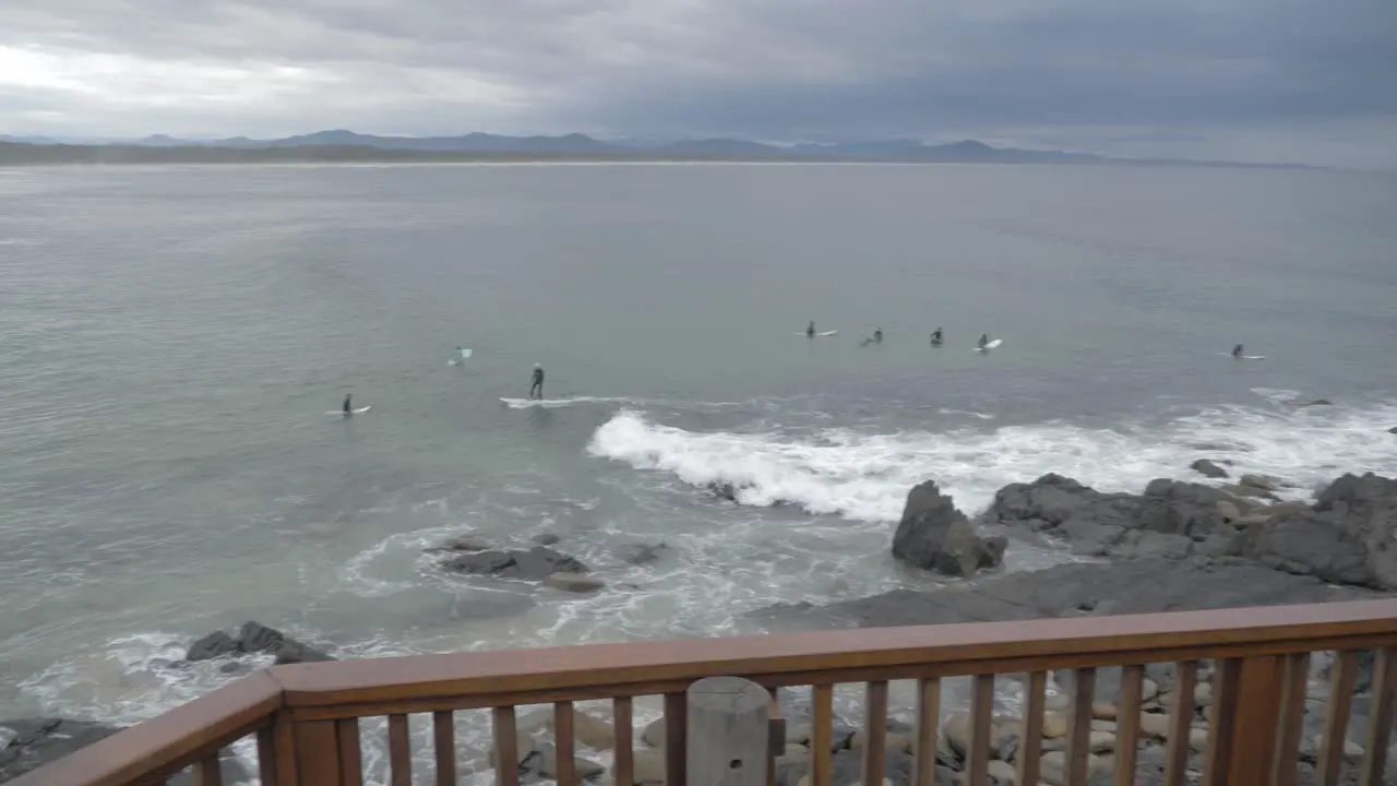 Australian Men Watching Surfers At The Beach On A Cloudy Day