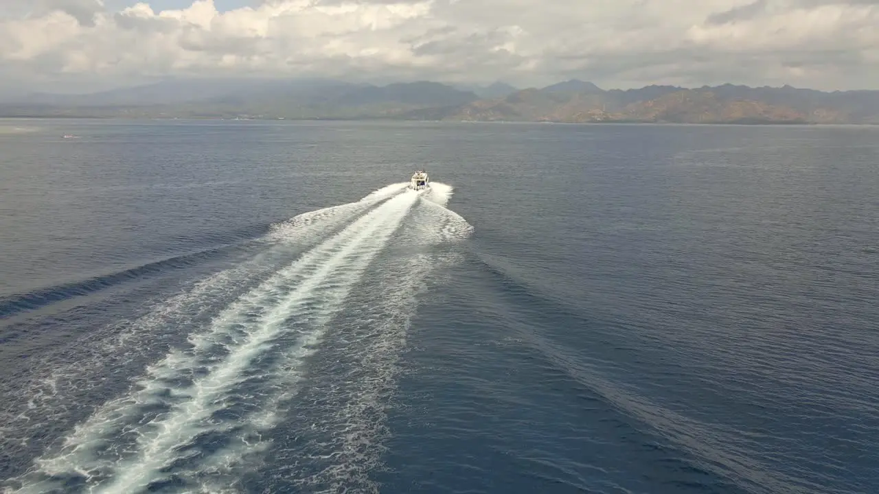 Aerial tracking shot of speedboat passing the Indian Ocean during sunny and cloudy weather