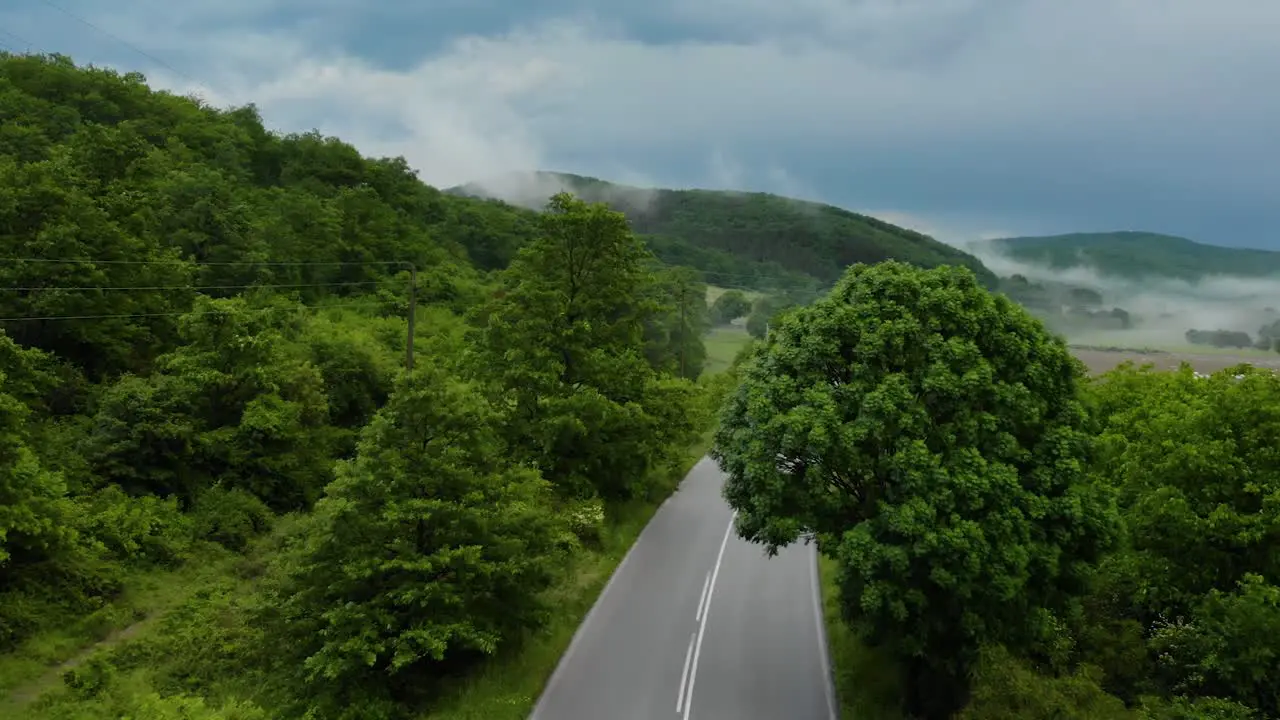 Car Passing By The Rural Road On A Cloudy Day aerial