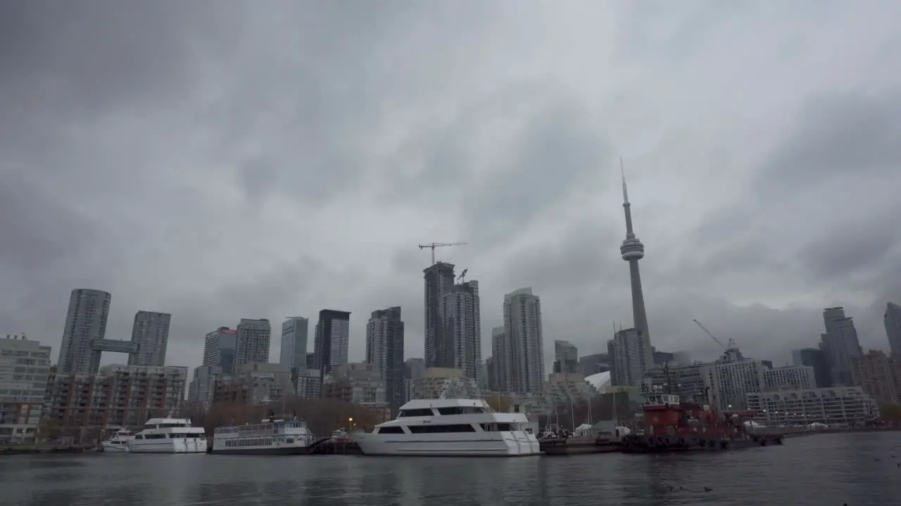 Static shot of boats moored in Toronto Harbourfront with the skyline in the background on a cloudy day