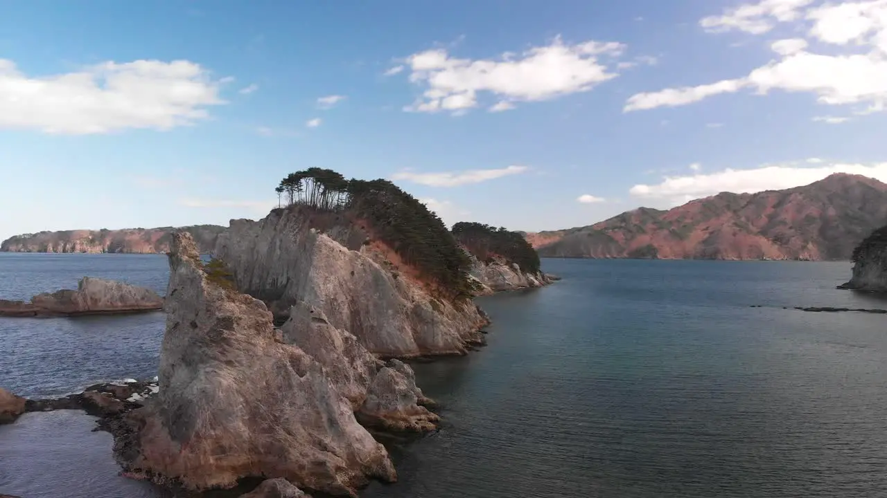 Slow cinematic aerial flight forward over beautiful rocky cliffs in ocean