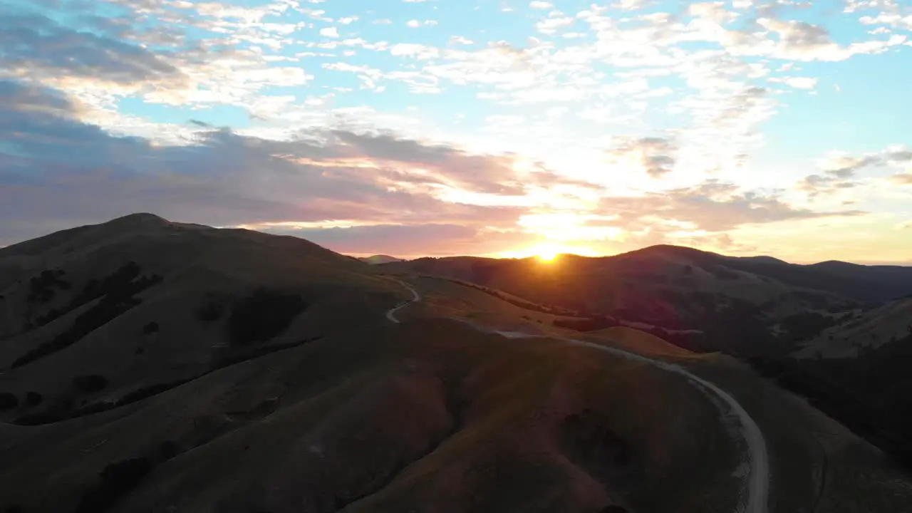 Colorful sunrise over a peaceful winding road and hills