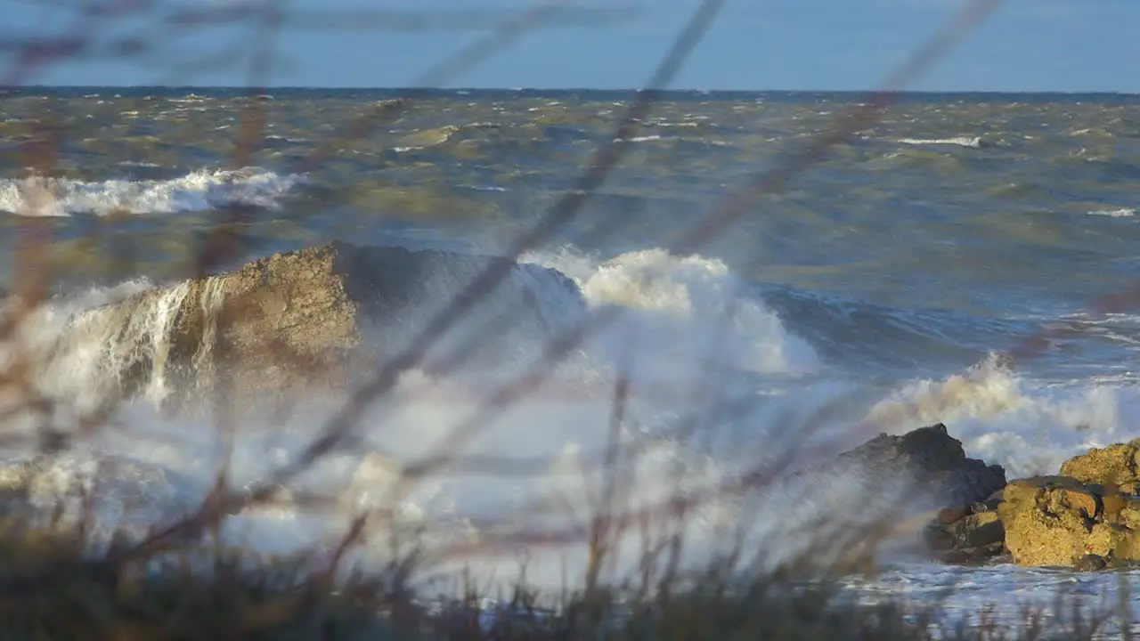 Big stormy waves breaking against abandoned seaside fortification building at Karosta Northern Forts in Liepaja slow motion medium shot