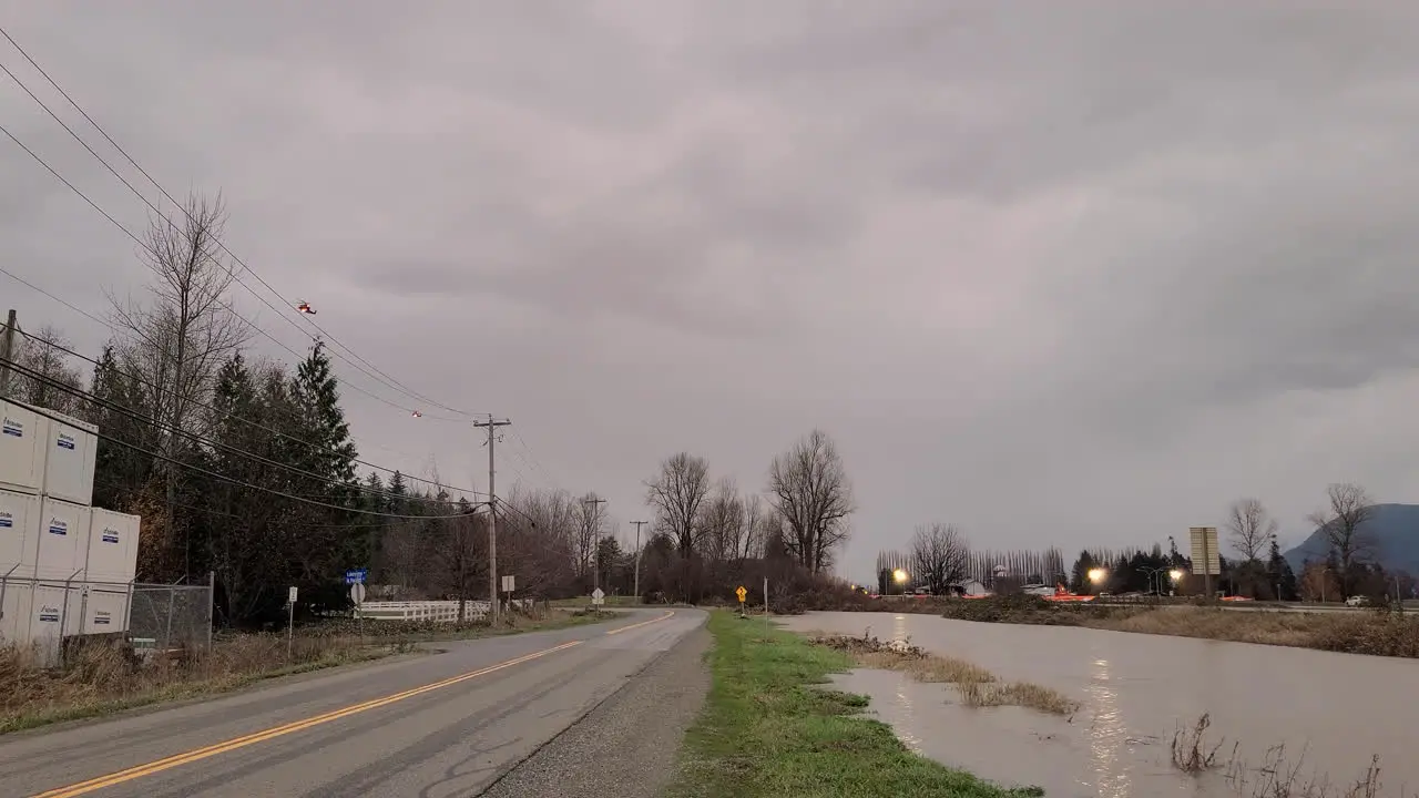 Helicopters Hovering Above The Overflowing River Near The Road During Stormy Day In The Abbotsford BC Canada