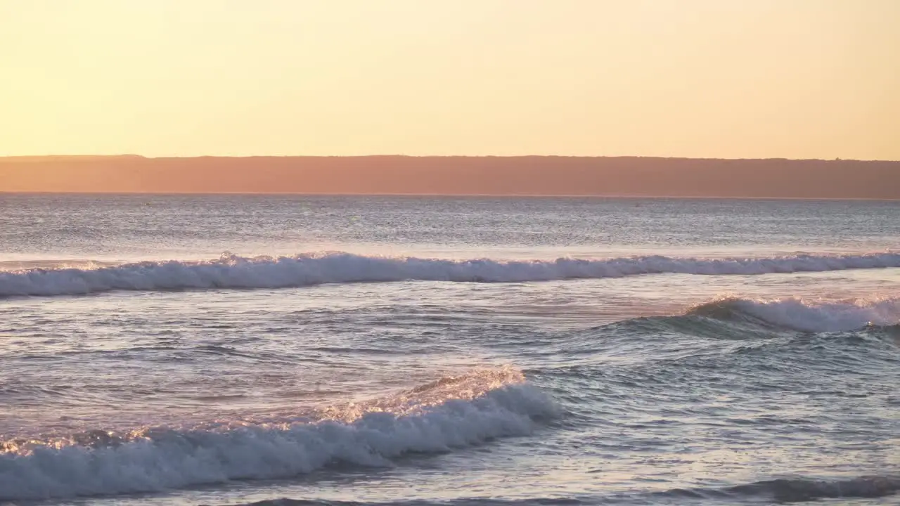 View of Atlanterra Beach in Zahara de los atunes Cadiz Spain waves crashing during beautiful sunset with orange glow colors