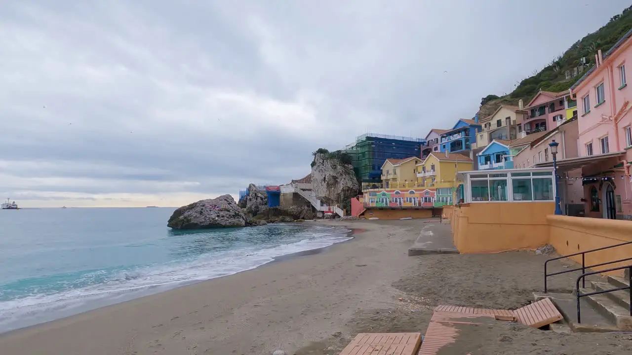 Timelapse of sea waves crashing at the colorful houses in Catalan bay Gibraltar