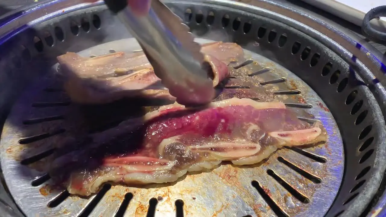 Cooking Korean BBQ on a hot stainless steel grill at a Korean restaurant