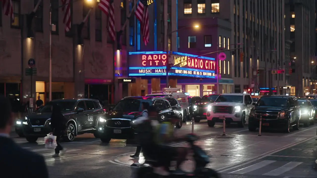 Radio City Music Hall neon sign lights busy intersection at night