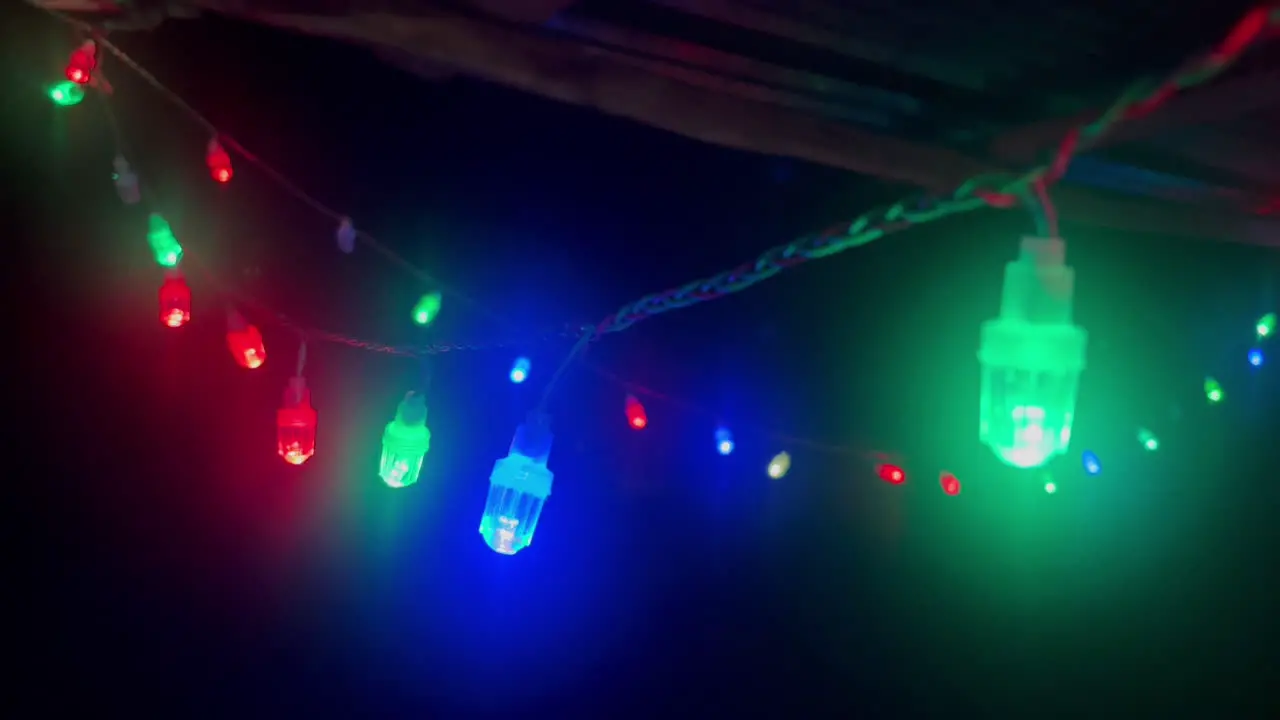 Close up of colorful twinkling lights adorning roof eaves