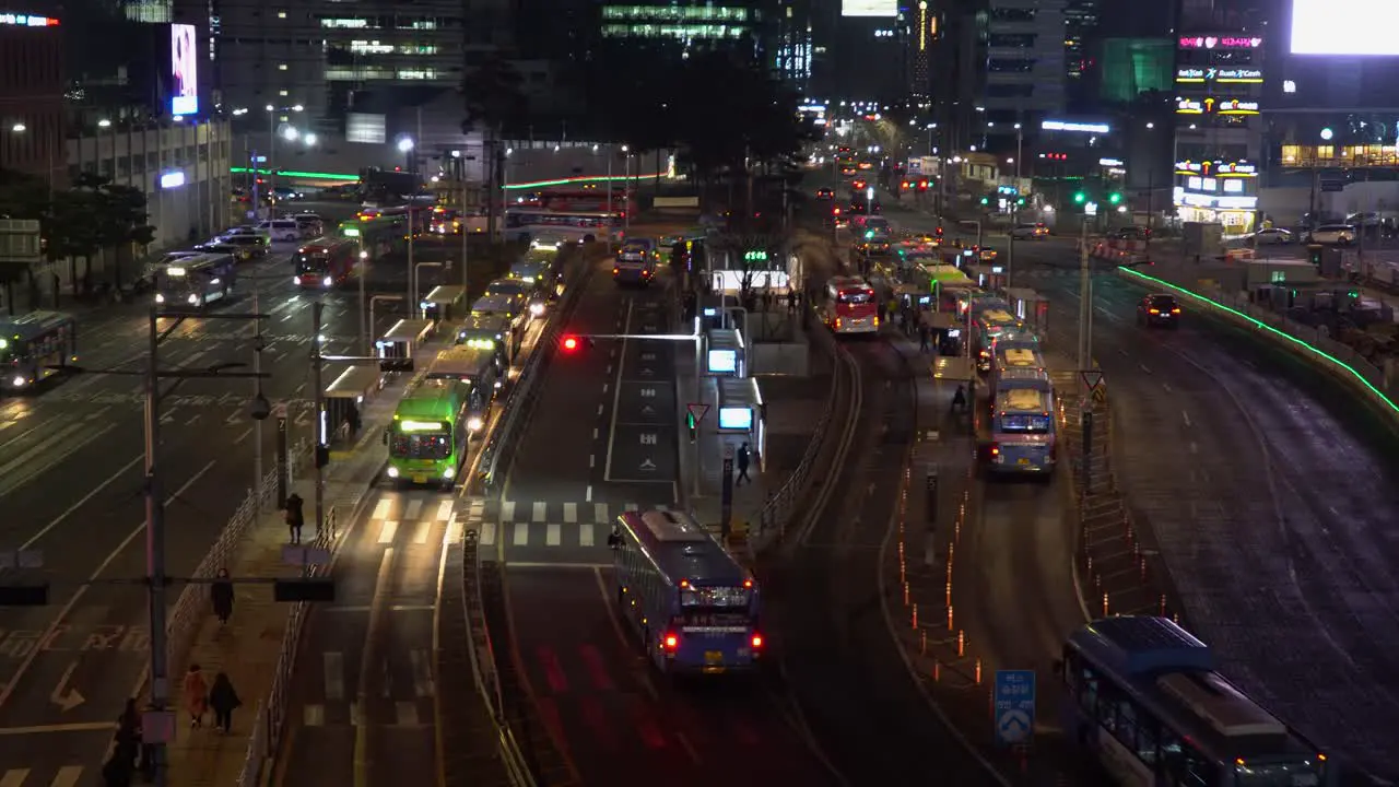 City life in Seoul South Korea with an establishing shot of a central bus stop at night